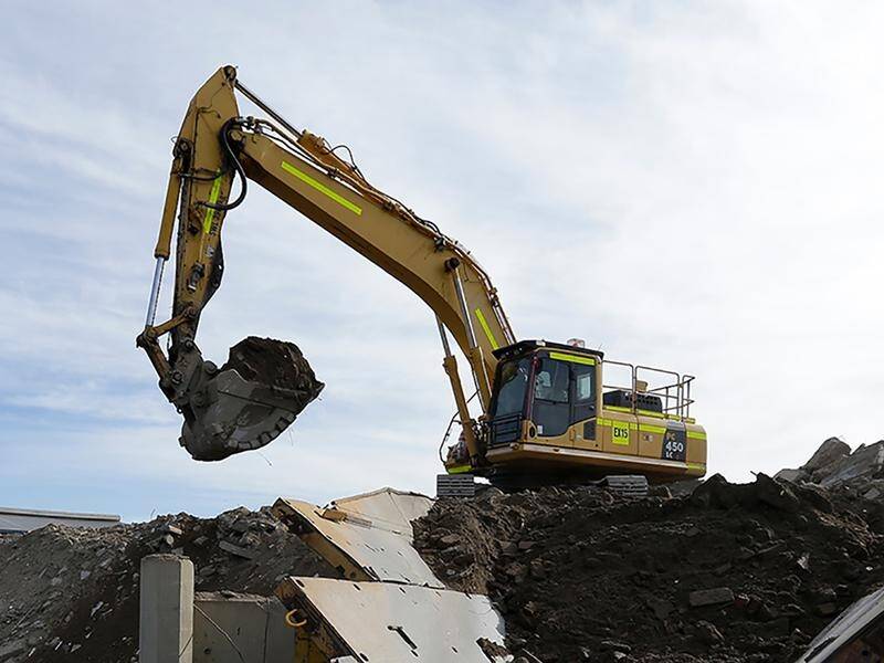 Excavator working among waste at a landfill site
